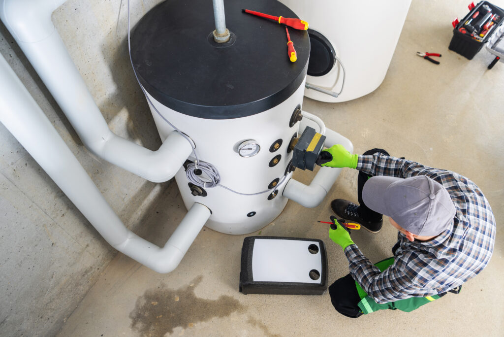 A technician is engaged in maintenance work on a water heater heat pump